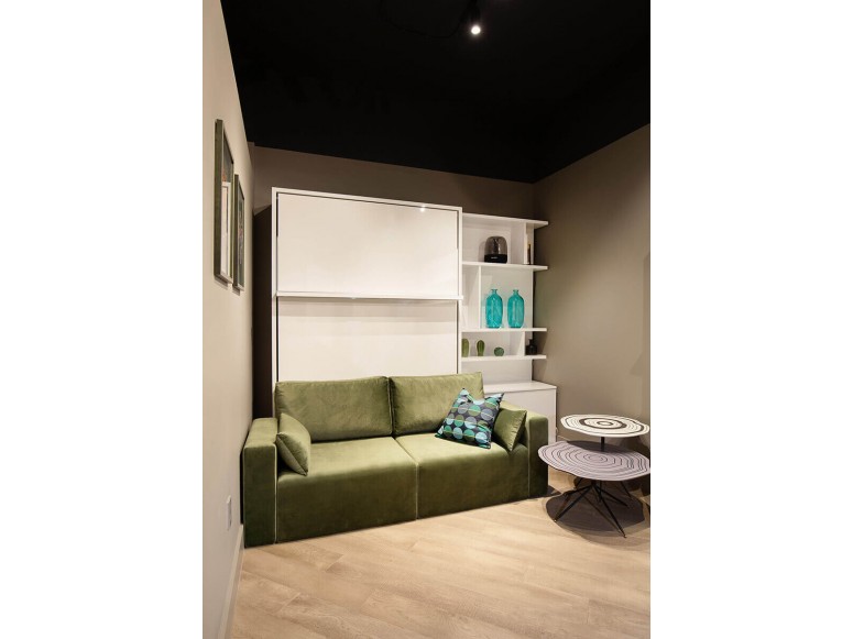 Long Island-themed room featuring the Royal Queen Murphy bed with sectional sofa and bookcase.